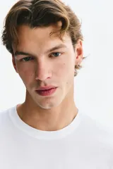 Remera de corte ajustado en punto suave de algodón pima, color blanco, con cuello redondo y mangas cortas.