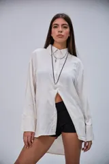 Camisa lisa de corte oversize en color beige, con cuello clásico, mangas largas y puños anchos.