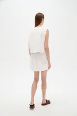Chaleco blanco sin mangas confeccionado en algodón, con cuello en V y diseño bordado.