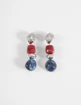 Caravanas largas compuestas por una pieza superior metálica de textura irregular, seguida de una cuenta cuadrada roja, una cuenta esférica plateada y una cuenta esférica azul con efecto marmolado.