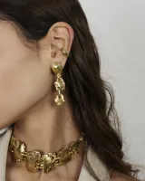 Aros colgantes de diseño orgánico con textura irregular, compuestos por tres piezas eslabonadas en acabado dorado. Incluye un earcuff a juego de diseño minimalista.