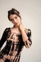 Bodysuit de manga larga con diseño ajustado al cuerpo y escote redondo, confeccionado con un llamativo estampado tie-dye en tonos marrones y negros.