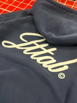 Hoodie azul marino de corte holgado con capucha amplia y estampado en la espalda con la palabra 'Ittab' en tipografía cursiva blanca.