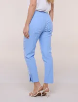 Pantalón ankle de tiro alto color blanco, confeccionado en tejido elástico con pretina ancha tipo pull-on, corte entallado y detalle de encaje calado en las aberturas laterales del ruedo.