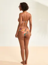 Conjunto de bikini con estampado multicolor de inspiración tropical y abstracta en tonos naranjas, rosas y verdes. El corpiño es de estilo triangular con frunce central y tirantes finos regulables, y la bombacha es de corte vedetina.