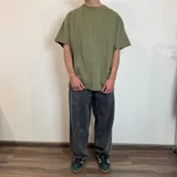 Remera de corte oversize en color verde oliva con efecto lavado, confeccionada en tela rústica pesada, con cuello redondo y bordes sin costura.
