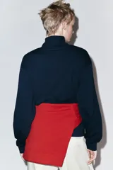 Sudadera roja de cuello alto con cierre frontal de cremallera y diseño de manga larga, con interior en tono contrastante.