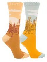 Calcetines de largo medio confeccionados en fibra de bambú, con diseño estampado de paisaje montañoso y bosque al atardecer. Presentan borde superior con terminación ondulada y logo de la marca.