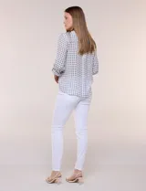 Blusa de gasa Zac & Rachel con estampado de rayas verticales en tonos rosados, amarillos y blancos. Presenta escote en V con cuello mao, cierre frontal con botones, un bolsillo aplicado en el pecho, mangas largas con presilla para regular el largo y detalle de nudo en el dobladillo inferior.