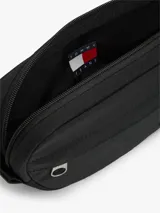 Riñonera Tommy Jeans negra de tejido ripstop, con compartimento principal con cierre, bolsillo exterior frontal con cierre, correa ajustable y parche con el logo de la marca en la parte delantera.