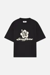 Remera de algodón color negro con corte boxy y cuello redondo acanalado. Presenta un estampado frontal con una flor de hibisco y el logotipo de la marca en tipografía cursiva, además de un pequeño logo impreso en la parte posterior.
