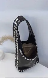 Cartera tipo hobo de cuero sintético color negro, con tachas plateadas en los bordes.