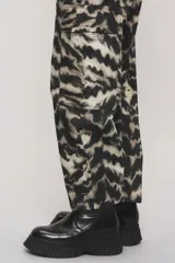Pantalón de corte regular con estampado animal print tipo cebra en tonos negro y beige, bolsillos laterales y recortes con doble costura.