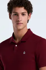Polo de manga corta en color bordó, confeccionada en tejido piqué de algodón. Presenta cuello clásico, cierre frontal con dos botones y el logo de la marca bordado en el pecho.