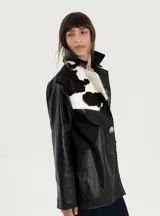 Blazer amplio de cuero vacuno color negro con detalles en cuero de vaca blanco y negro en cuello y solapas.