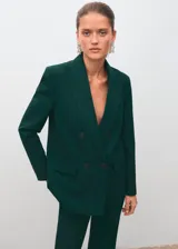 Blazer de corte recto y diseño estructurado, confeccionado en tejido mezcla de lana color verde oscuro. Presenta cuello con solapas de muesca, cierre frontal de doble botonadura, bolsillos de solapa laterales y bolsillo de ribete en el pecho. Incluye forro interior y mangas largas con puños abotonados.