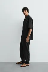 Pantalón relaxed fit de lino color negro, con cintura elástica ajustable con cordón y bolsillos frontales.