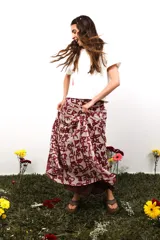 Falda larga de gasa con estampado tipográfico en tonos bordó sobre fondo beige. Presenta un diseño de doble tela con caída fluida y cierre lateral oculto.