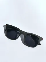 Lentes de sol con armazón de color gris mate y detalles en azul en las patillas. Cuentan con cristales oscuros polarizados y protección UV 400.