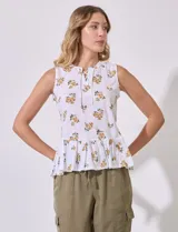 Blusa sin mangas de algodón estampado con flores amarillas, cuello a la base, escote en V y entrelazado. Terminación de ruedo con frunce.