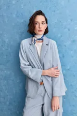 Blazer color beige claro, de corte clásico con solapa, cierre de un botón y bolsillos delanteros de vivo.