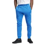 Pantalón de jogging azul con cintura elástica y cordón ajustable, bolsillos laterales con cierre y logo de Adidas bordado en blanco.