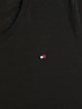 Remera negra de corte slim, cuello redondo y manga corta con dobladillo. Logo de Tommy Hilfiger bordado en el pecho.