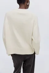 Buzo de punto suave con corte holgado, cuello redondo y mangas raglán. Presenta terminaciones acanaladas en el cuello, los puños y el bajo.