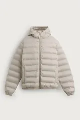 Campera puffer ligera de corte regular, color beige, con tejido técnico repelente al agua. Cuenta con cuello subido, capucha, mangas largas con elásticos en los puños, bolsillos laterales de vivo y cierre frontal con cremallera.