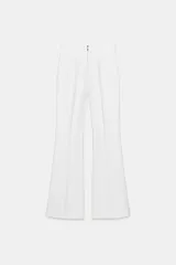 Pantalón de tiro alto en color negro, con diseño de corte recto y ligeramente acampanado. Presenta costuras verticales marcadas en el frente y bolsillos laterales de vivo.