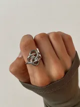 Anillo de acero con diseño entrelazado y ajustable.