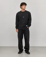 Buzo de algodón color negro, con cuello redondo, mangas largas y puños acanalados. Presenta un pequeño logo ovalado en el centro del pecho y una etiqueta pequeña en el ruedo.