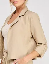 Blazer corto de lino color beige, marca Allie Rose, de estilo relajado y corte crop con frente abierto sin botones. Presenta solapa de muesca y mangas tres cuartos con detalle fruncido en los laterales.