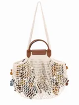 Cartera de red grande Longchamp de la línea Le Pliage Filet Camo, con diseño de red decorado con apliques de flores y solapa con asas de cuero marrón.