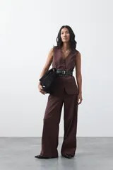 Chaleco sastrero de color marrón, con silueta recta, escote en V y cierre frontal con botones. Presenta una estructura definida y tejido con caída firme.