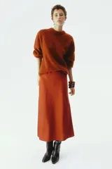 Pollera midi de tejido satinado color terracota, con corte fluido, elástico oculto en la cintura y leve vuelo en el bajo.