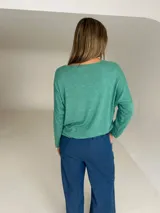 Sweater de tejido de punto color verde agua, con cuello redondo, mangas largas y diseño holgado con caída fluida.