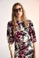 Top de mangas 3/4 con estampado abstracto en tonos borgoña, negro, blanco y verde.