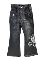 Jean de corte oxford y tiro bajo, color negro con efecto lavado. Presenta estampa bordada en la parte inferior de una de las piernas y detalles de costuras reforzadas en las rodillas.