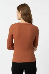 Remera de manga larga confeccionada en tejido de punto canalé, con ajuste al cuerpo y cuello redondo.