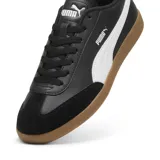 Championes Puma modelo 9-T, de diseño urbano con capellada en color negro, franja lateral característica en blanco y suela de goma color caramelo.