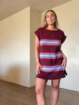 Vestido corto de punto de algodón color bordó, con diseño de rayas horizontales en tonos celestes y rojos, silueta recta y cuello redondo sin mangas.