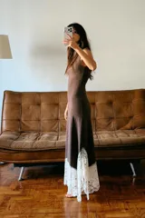 Vestido largo de cuello perkins y diseño sin mangas, confeccionado en tejido de punto color marrón. Presenta un bajo con corte evasé y detalle de encaje en color crudo a contraste. Cierre posterior con cremallera oculta.