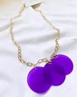 Collar dorado con cadena de eslabones y tres dijes circulares de nácar color violeta.