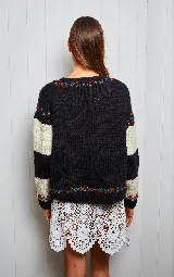 Sweater tejido de lana con diseño de rayas horizontales en blanco y negro, y aplique de un mono en el centro. Tiene cuello redondo y puños ajustados con detalles bordados.