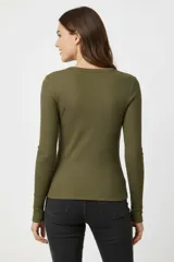 Remera de manga larga con cuello redondo a la base, confeccionada en tejido de algodón con elastano de textura acanalada.