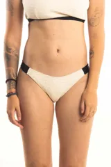 Bombacha de bikini tipo vedetina, color crema con textura, y laterales anchos en color negro.