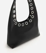 Cartera hobo de tamaño mediano, confeccionada en PU con forro de poliéster. Cuenta con asa de hombro integrada decorada con ojales metálicos plateados a lo largo de toda su estructura.