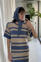 Vestido tejido artesanalmente en hilado 70% algodón y 30% acrílico, con diseño a rayas horizontales en tonos beige y azul.