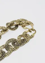 Collar gargantilla de eslabones grandes dorados con textura.